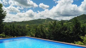 Een buitenzwembad, parasols voor strand/zwembad