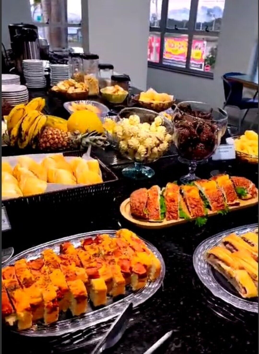 Buffet amb diversos plats, incloent fruita, sandvitxos i postres.