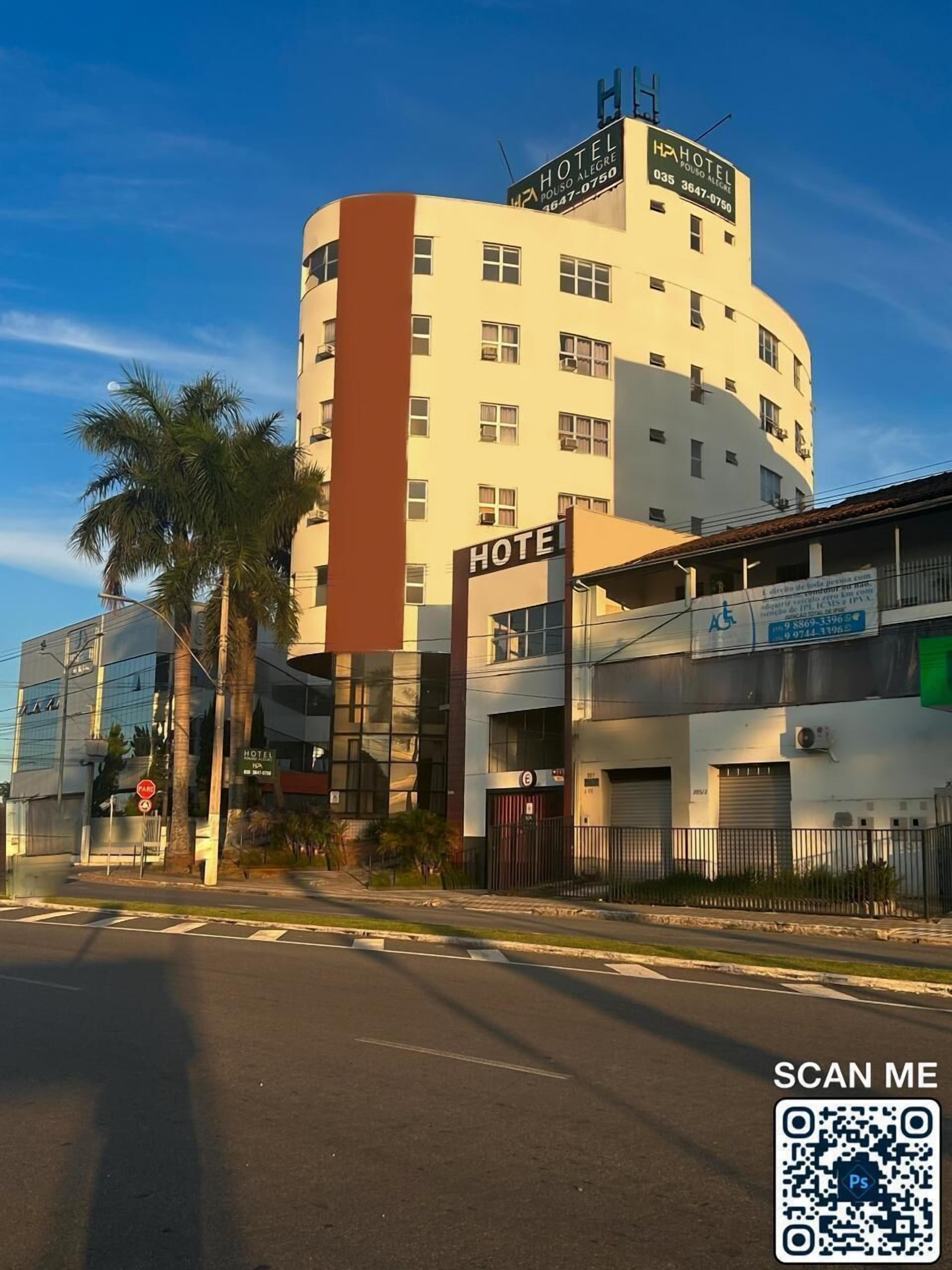 A hotel with a prominent 'HOTEL' sign, multiple windows, and a parking area with a 'PARKING' sign.