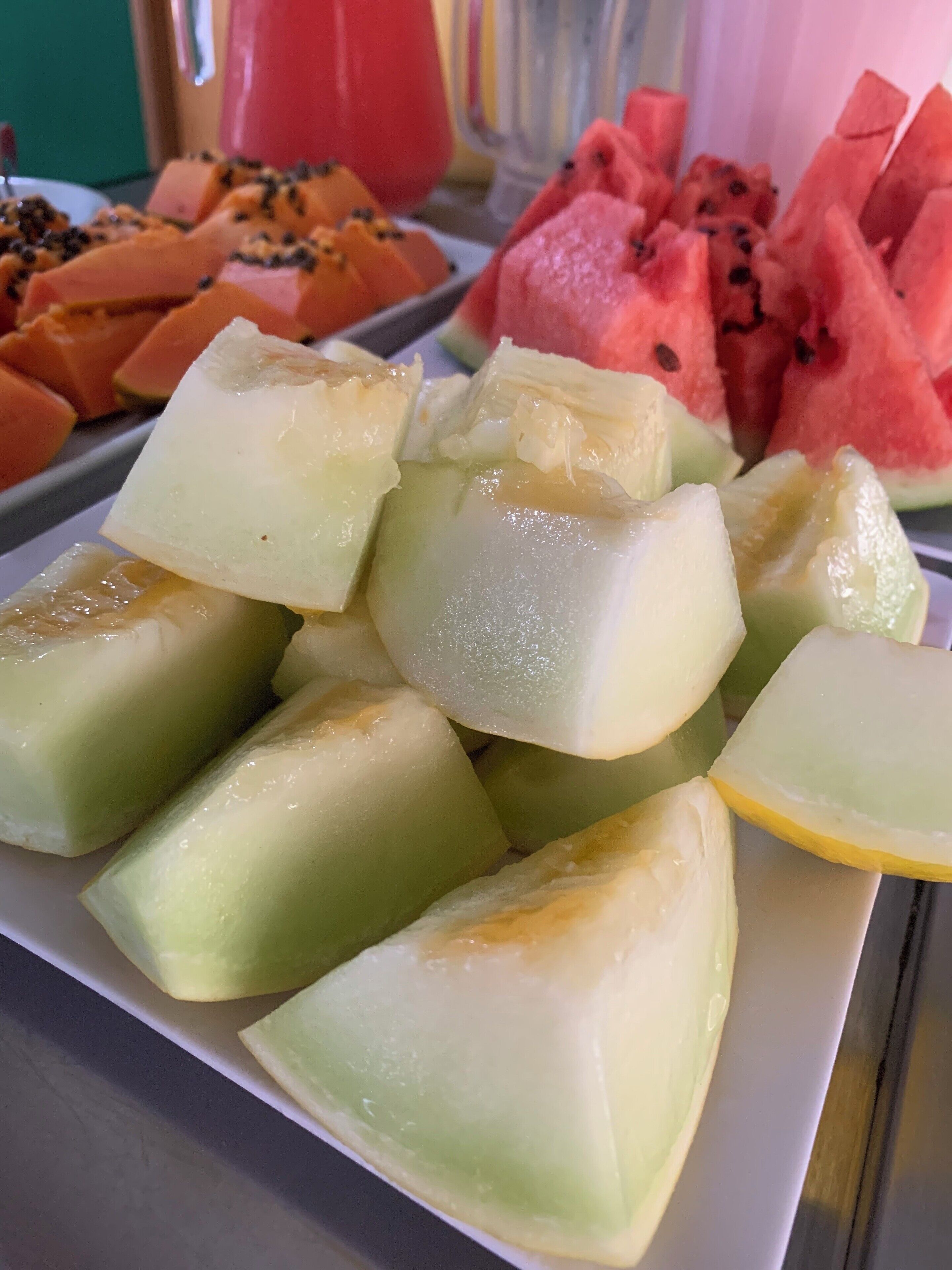 A plate of assorted fruits including melon, papaya, and watermelon.