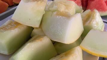 A plate of assorted fruits including melon, papaya, and watermelon.