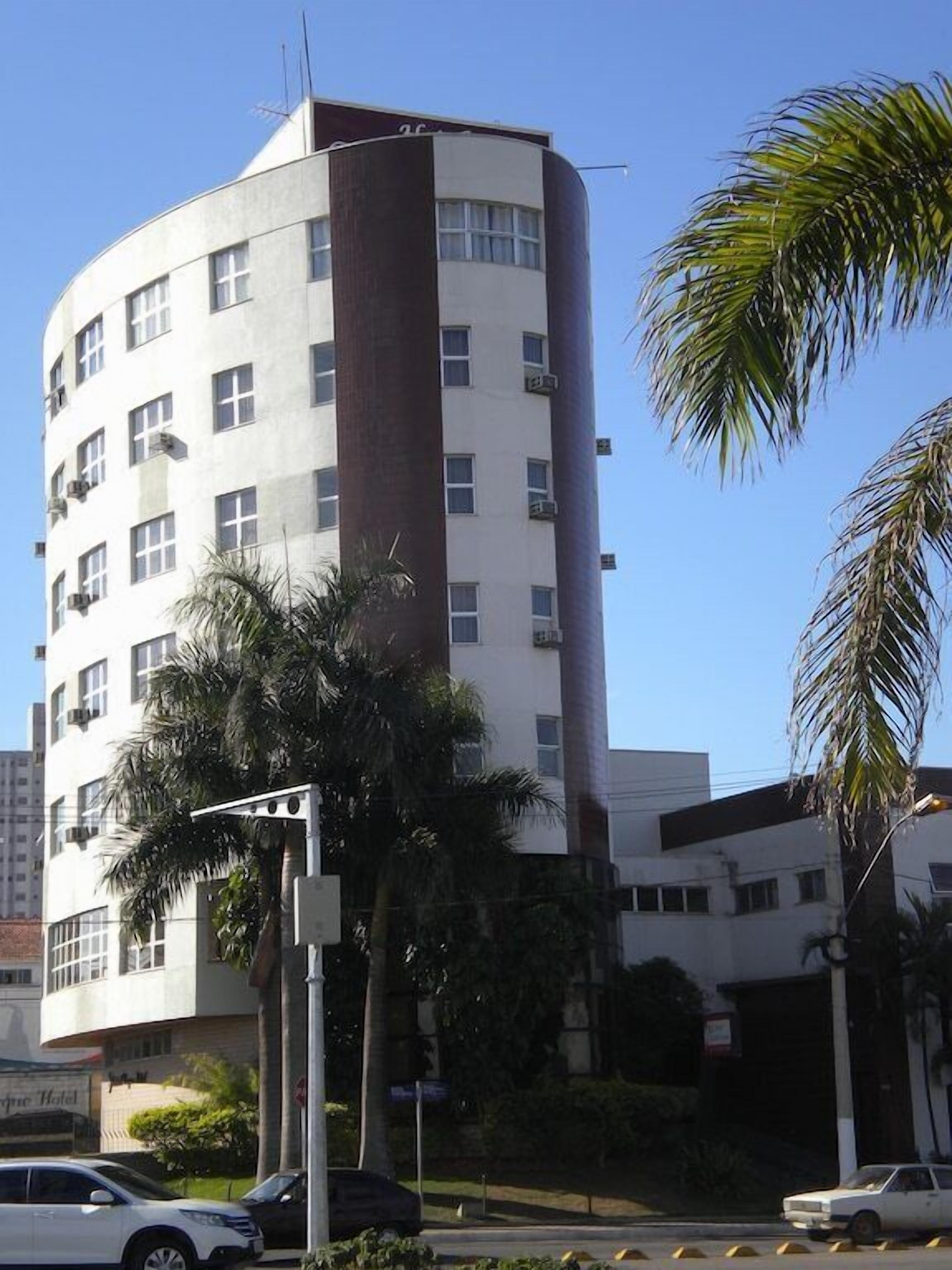 A multi-story building with a curved facade, several windows, and a visible entrance.