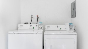 Two white Whirlpool washing machines with control panels, hoses, and a water meter on a white wall. - Cozy 1 Bed, Sleeps 4! Near Strip! Perfect GetAway! (Las Vegas)