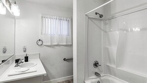 A bathroom with a white sink, mirror, and shower. - Cozy 1 Bed, Sleeps 4! Near Strip! Perfect GetAway! (Las Vegas)