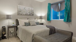 A bedroom with a bed, bedside tables, lamps, a window with curtains, and a wall-mounted artwork. - 1 Bedroom/ 1 Bath Suite in The Copperleaf Villas (Centennial)
