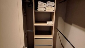 A walk-in closet with multiple shelves and drawers, a hanging rod, and a ceiling light. - Nice and comfortable apartment in San Diego 376, Santiago (Santiago)