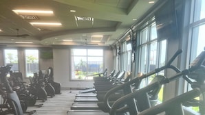 Ein Fitnessraum mit Laufbändern und Ergometer, die in Reihen angeordnet sind.