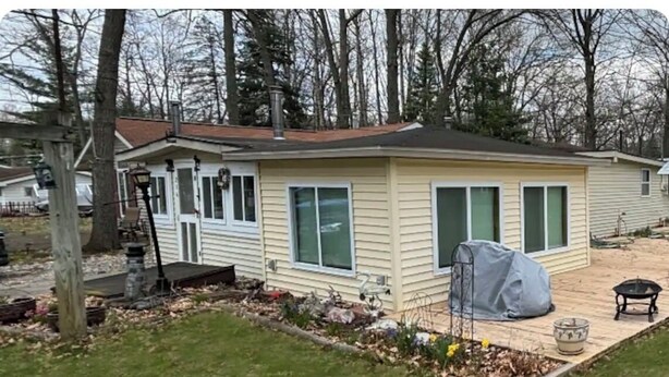A single-story house with a front porch, a covered patio, and a small garden area. - Lakeside Haven  (Houghton Lake)