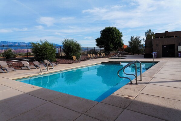 A swimming pool with lounge chairs and a view of mountains. - Courtyard: Golf + Resort Access + Sand Dunes (Hurricane)
