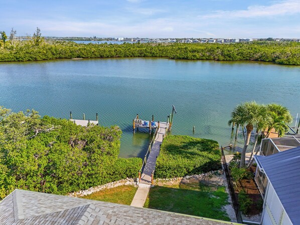 A waterfront property with a dock, lush greenery, and a clear view of the water.