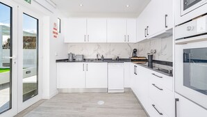 Una cocina moderna con armarios blancos, lavavajillas y horno integrado.