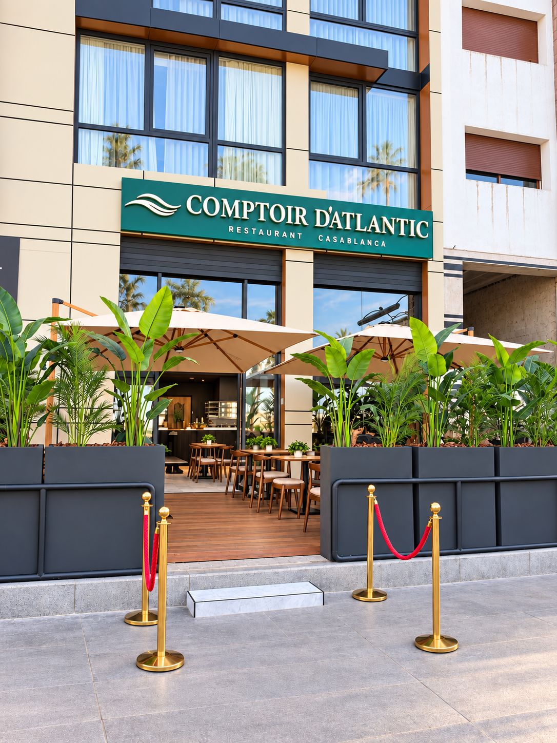 A hotel entrance with outdoor seating and a sign for Comptoir D'Atlantic Restaurant.