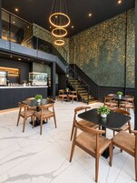 Un interior moderno con una zona de bar, asientos y una escalera.
