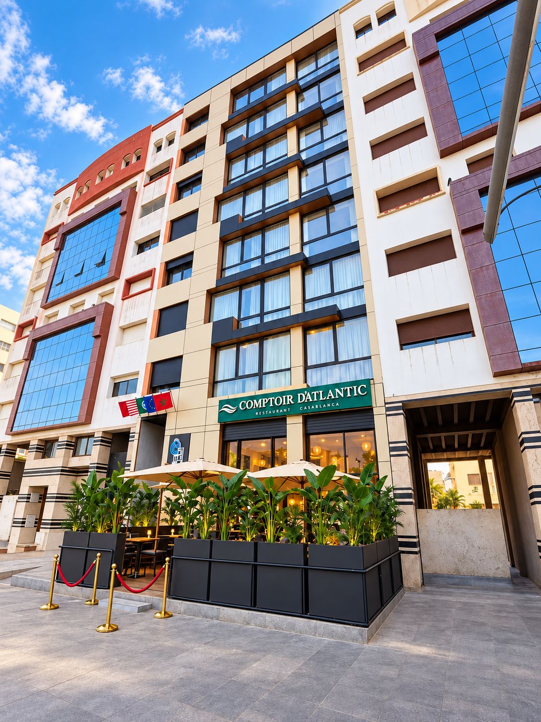 A hotel with a modern facade, multiple floors, and a restaurant named 'Comptoir D'Atlantic' on the ground floor.
