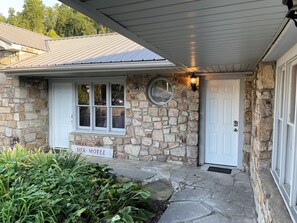 A stone building with a sign reading "Fox Motel," a white door, and a window with a view of the street.