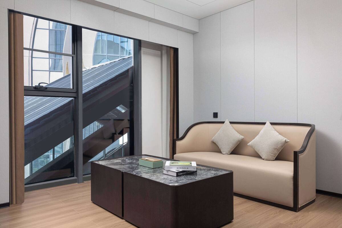 Ein modernes Interieur mit einer Couch, einem Couchtisch und Blick auf eine Treppe.
