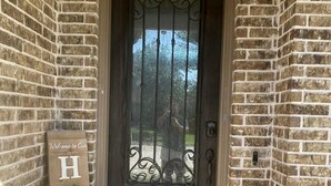 A brick house entrance with a dark wooden door, a welcome sign, and a doormat. - PGA HQ Area, Sleeps 10, King-Size Beds for Groups (Little Elm)