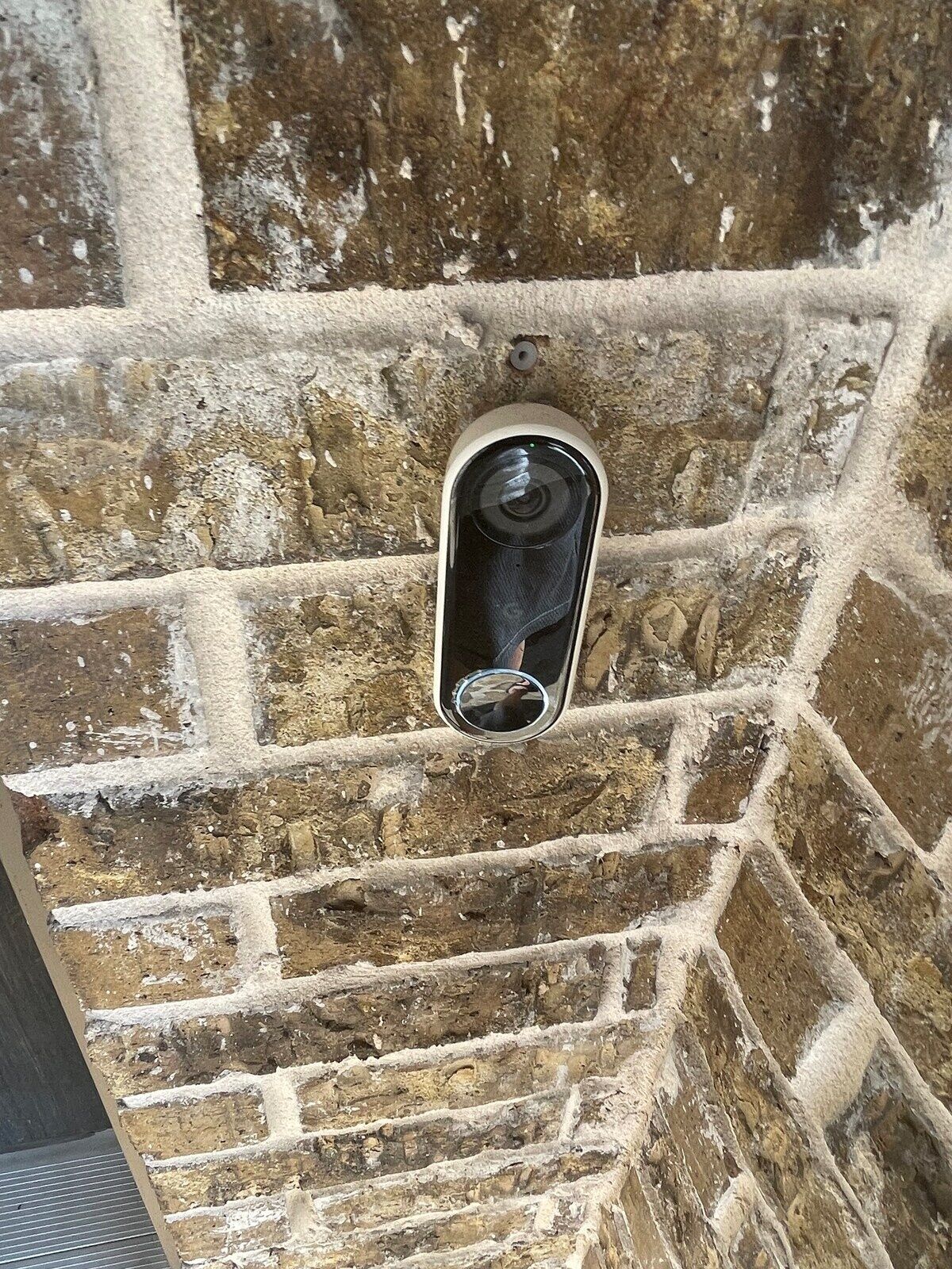 Puerta con una manija moderna sobre un muro de ladrillo.
