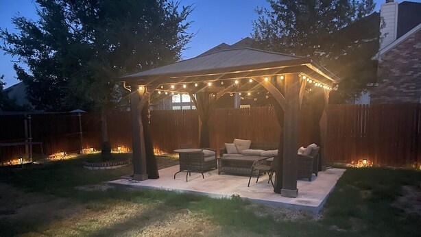 A covered patio area with outdoor furniture and string lights. - PGA HQ Area, Sleeps 10, King-Size Beds for Groups (Little Elm)