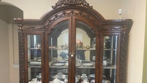 A large, ornate wooden display cabinet with multiple glass doors, each containing various dishes and silverware. - PGA HQ Area, Sleeps 10, King-Size Beds for Groups (Little Elm)