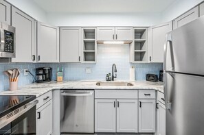 Een koelkast, een magnetron, een kookplaat, een vaatwasser