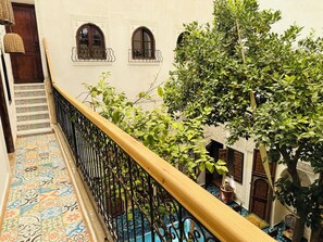 A staircase with patterned tiles leading to a balcony with a wrought iron railing. - Riad Dar El Bacha (Marrakech)