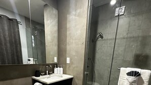 A modern bathroom with a toilet, sink, and shower.