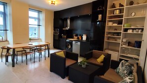 Une cuisine moderne avec un coin repas, un canapé et une bibliothèque.