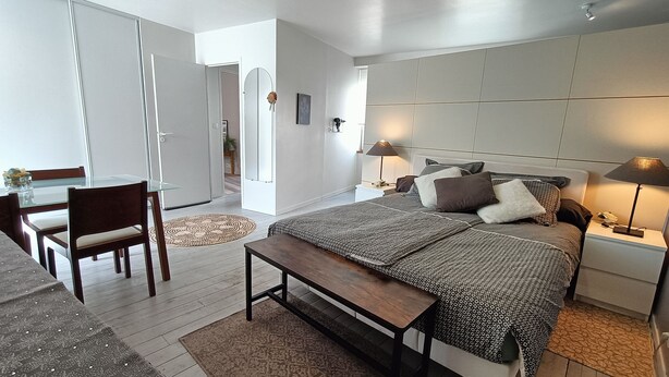 Une chambre moderne avec un grand lit, des tables de chevet, un bureau et une chaise.