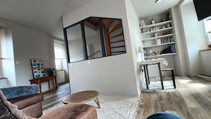 Un salon moderne avec un escalier, une bibliothèque et un coin repas.