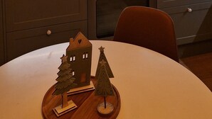 A modern kitchen with wooden cabinets, a white countertop, and pendant lights with exposed bulbs. - Magical and Cosy apartment with tree views from every window! (Rovaniemi)