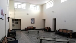 Una habitación amplia con varias zonas de estar, incluyendo bancos y una mesa de vidrio.