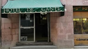 Exterior del Hotel De Gante con un toldo verde y un letrero sobre la entrada.