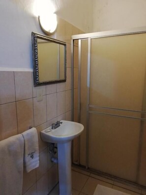 Een douche, handdoeken, zeep, shampoo