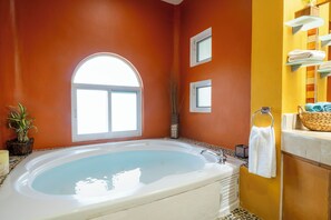 A bathroom with a large bathtub, a window, and a mirror with towels. - 3 Bedroom villa with pool - Mayamar G9 (Playa del Carmen)