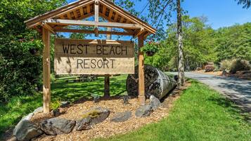 Un letrero de madera para el West Beach Resort.