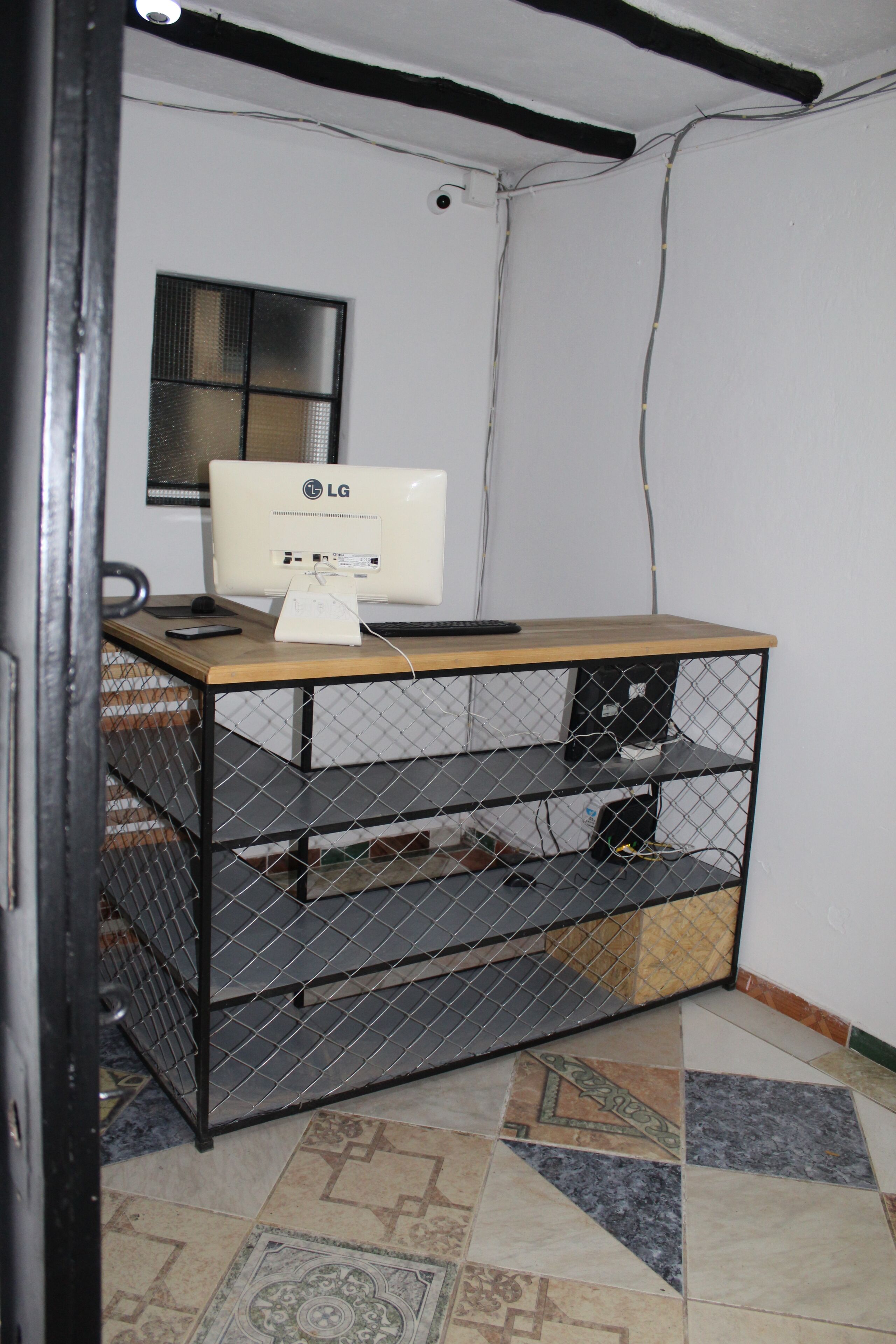 A room with a desk, a computer, and a chair.