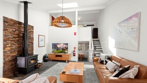 Una sala de estar moderna con chimenea, un sofá, una mesa de centro y un televisor.