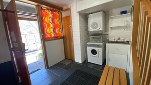 Ein kleiner Hauswirtschaftsraum mit Waschmaschine, Trockner und Spüle.