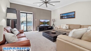 A modern living room with a sofa, a coffee table, a TV, and a painting on the wall. - Snow Creek 4 - Thredbo (Thredbo)