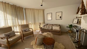 A cozy living room with a sofa, armchair, and a small round table. - Sitzmark 1 - Central Village location (Thredbo)