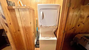 A compact room with a wooden interior, a white washing machine, and a small cabinet. - The Old Home Place in amazing Mountain View, close to the courthouse square (Mountain View)
