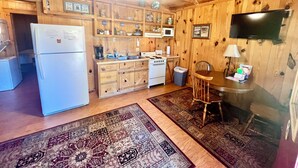 A wooden cabin interior with a kitchen, dining area, and a ceiling fan. - The Old Home Place in amazing Mountain View, close to the courthouse square (Mountain View)