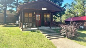 A small wooden cabin with a porch, a red door, and a sign reading "The Old Home Place". - The Old Home Place in amazing Mountain View, close to the courthouse square (Mountain View)