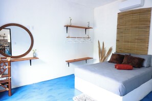 Relax in this serene bedroom with a comfortable bed, wooden headboard, and large mirror.