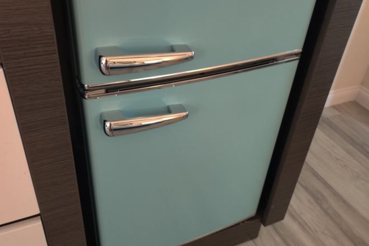 A teal-colored cabinet with two chrome handles.