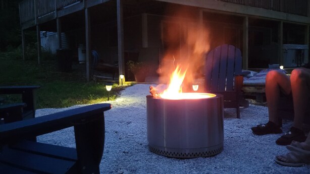 Ein Gebäude mit einer Holzterrasse und einem Feuerkorb im Vordergrund.