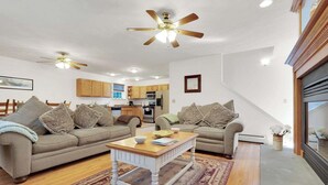 Ein Wohnzimmer mit zwei Sofas, einem Couchtisch und einem Deckenventilator.