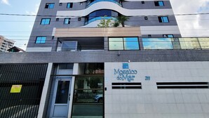 A modern building with a curved facade, multiple balconies, and a ground-level entrance labeled "Mosaico do Mar 211". - Perto da Praia: Wi-Fi, Piscina e Garagem (Maceió)