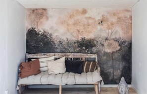 Een kamer met een bed tegen een muur, versierd met een natuurdecoratie.